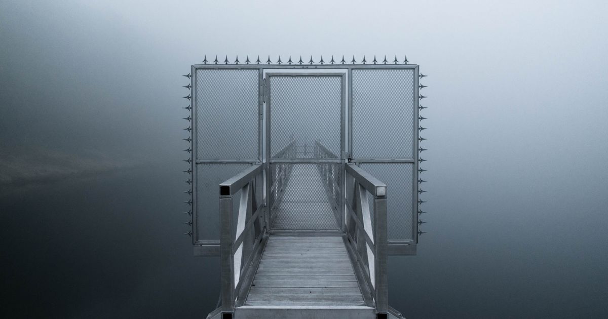 A footbridge disappearing into thick fog